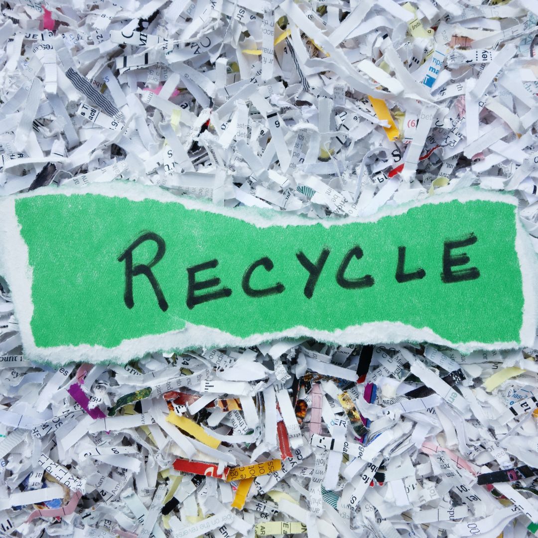 A symbolic image of recycled paper rolls, a green recycling symbol, and Earth in the background, representing paper recycling and its environmental impact.